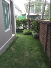 A small garden area with a view of neighboring house