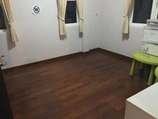 Empty bedroom with hardwood flooring and curtains