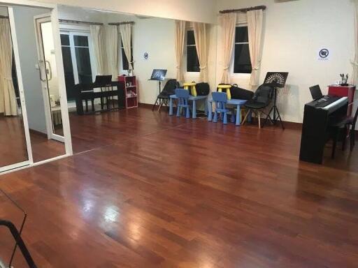 Spacious room with hardwood floors and musical instruments