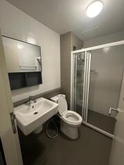 Modern bathroom with sink, toilet, and shower enclosure