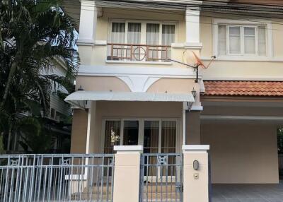 Exterior view of a two-story house with a gated entrance