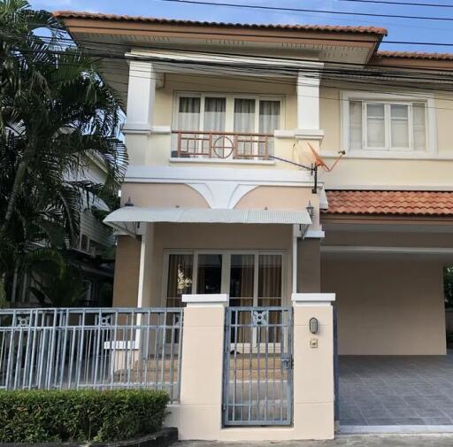 Exterior view of a two-story house with a gated entrance