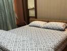 Bedroom with a double bed, patterned bedsheet, and pillows