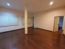 Spacious empty living room with wooden flooring and recessed lighting