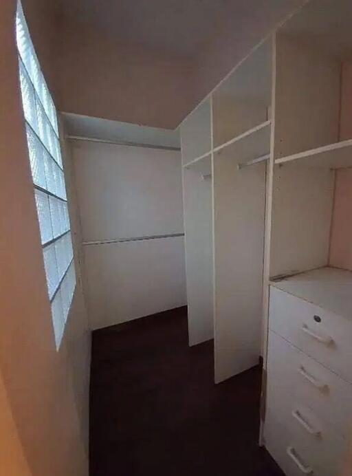 Spacious walk-in closet with shelving and drawers