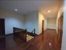 Second floor hallway with wooden flooring and staircase