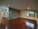 Spacious living room with hardwood floors and large windows