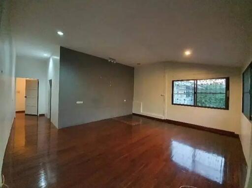 Spacious living room with hardwood floors and large windows