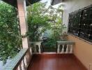 A balcony with tiled floor and railing overlooking trees