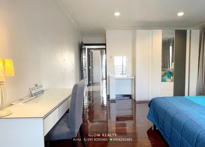 Modern bedroom with desk, wardrobe, and blue bedding