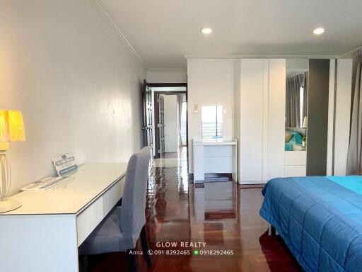 Modern bedroom with desk, wardrobe, and blue bedding