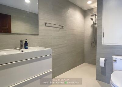 Modern bathroom with sink, shower area, and toilet