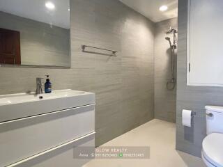 Modern bathroom with sink, shower area, and toilet