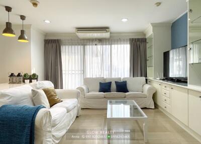 Bright and spacious living room with white sofas and natural lighting