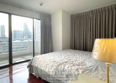 Bedroom with a bed, large window, and city view