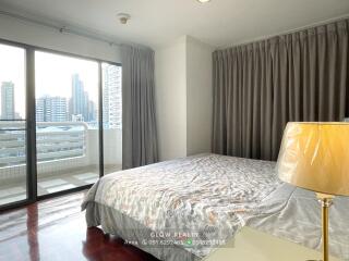 Bedroom with a bed, large window, and city view