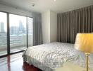 Bedroom with a bed, large window, and city view