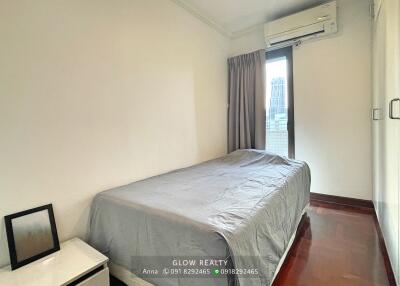 Modern bedroom with a bed, window, and air conditioning unit