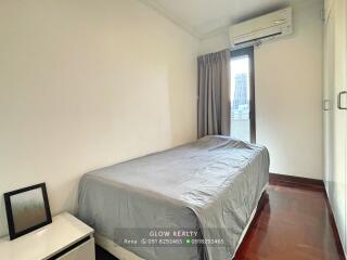 Modern bedroom with a bed, window, and air conditioning unit