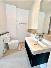 Contemporary bathroom with white fixtures and large mirror