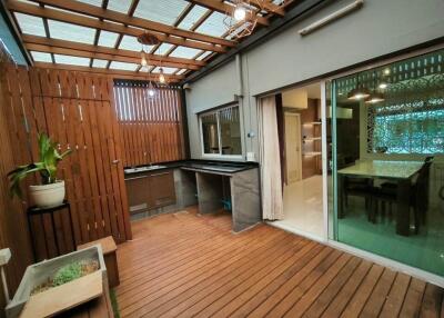 Covered outdoor patio area with a view into the dining room