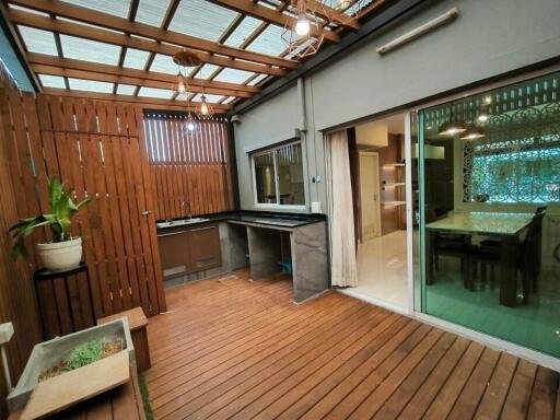 Covered outdoor patio area with a view into the dining room