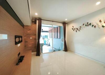 Spacious living room with large glass doors leading to an outdoor area, featuring modern decor