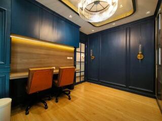 Modern home office with two desks and blue cabinetry