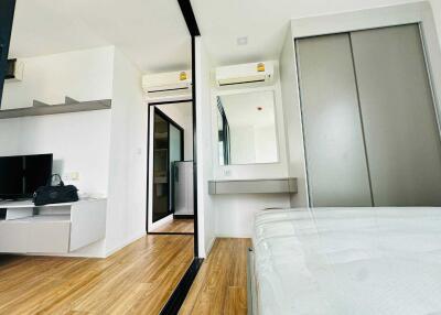 Modern bedroom with air conditioning, sliding door closet, and wooden flooring