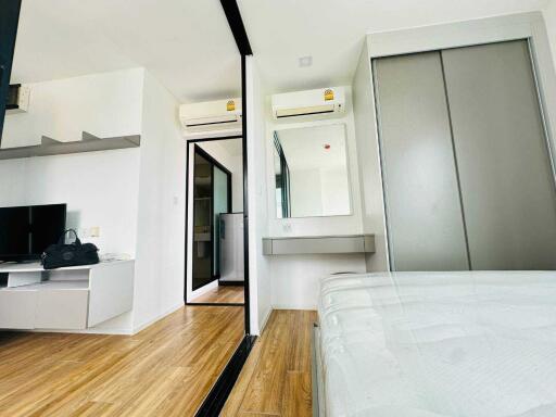 Modern bedroom with air conditioning, sliding door closet, and wooden flooring