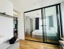 Modern bedroom with hardwood floors and glass wall partition