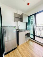 Compact kitchen with stainless steel refrigerator and built-in cabinetry