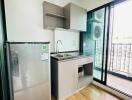 Compact kitchen with stainless steel refrigerator and built-in cabinetry