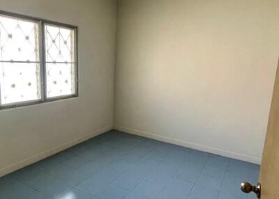 Empty bedroom with tiled floor and a window