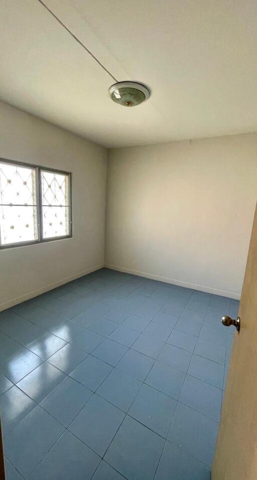 Empty bedroom with tiled floor and a window