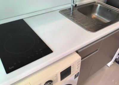 Modern kitchen with stovetop, sink, and washing machine