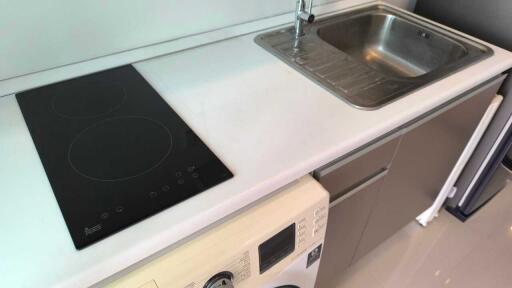 Modern kitchen with stovetop, sink, and washing machine