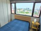 Bedroom with blue bedspread and city view