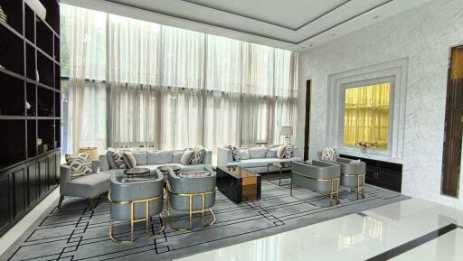 Luxurious modern living room with ceiling-to-floor windows and contemporary furnishings