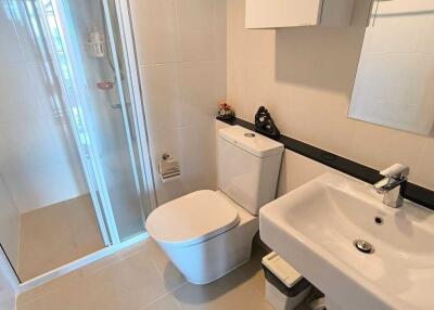 Modern bathroom with glass shower, sink, and toilet