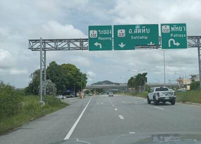 View of a road with directional signs to Rayong, Sattahip, and Pattaya