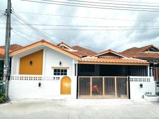 Exterior view of a house with a gated driveway and a small covered entrance