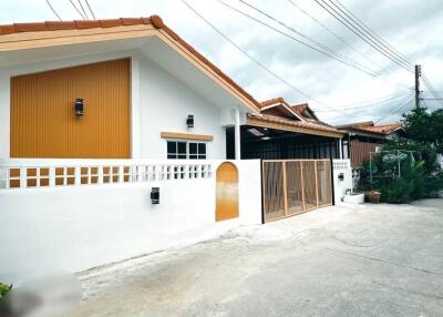 Exterior view of a house with white walls and orange roof tiles