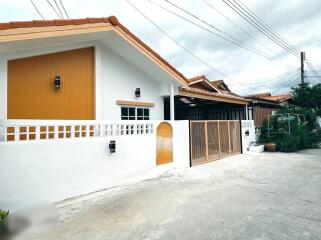 Exterior view of a house with white walls and orange roof tiles