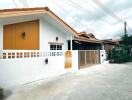 Exterior view of a house with white walls and orange roof tiles