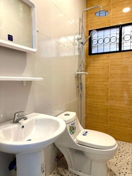 Modern bathroom with shower, vanity, and toilet