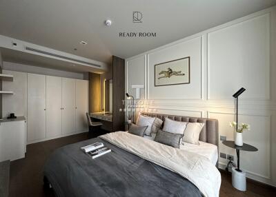 Modern bedroom with a bed, side table, desk, and closet