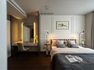 Modern bedroom with a large bed, a vanity desk, and stylish decorations