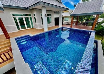 Outdoor pool area with adjacent modern house