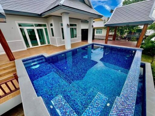 Outdoor pool area with adjacent modern house